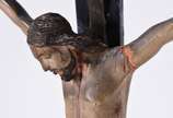 Crucifixo de madeira nobre com figura de Cristo... - Crucifixo de madeira nobre com figura de Cristo ricamente entalhada.(Resplendor faltando partes, e metal com desgastes).