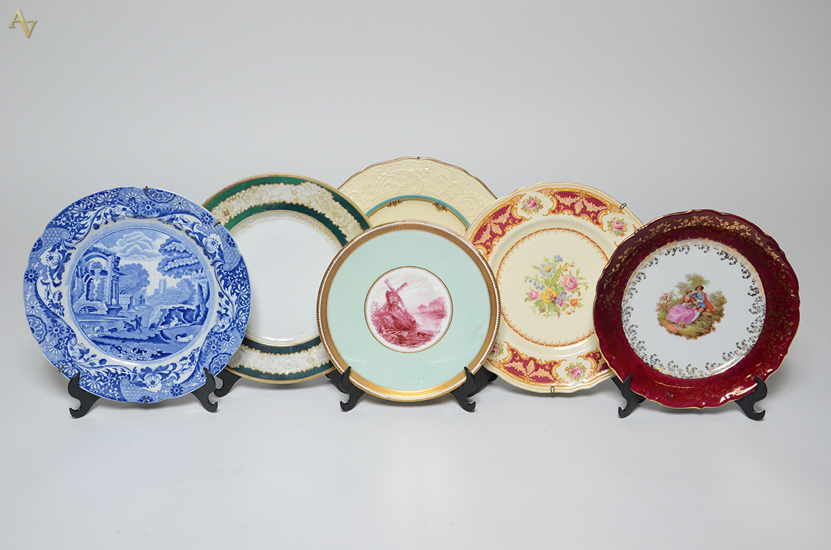 Seis pratos com decorações diversas, sendo três em porcelana e três...