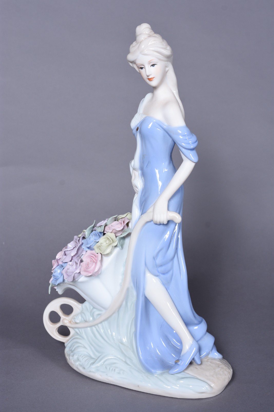 Estatueta de porcelana policromada representando dama com carrinho de... - foto 1 de 8
