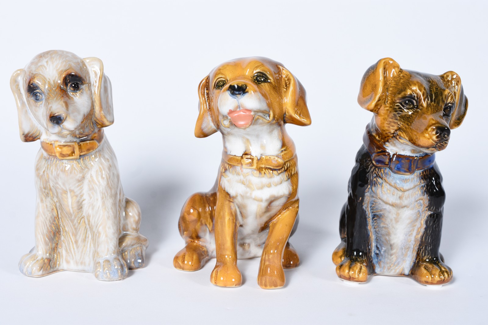 Três pequenas esculturas representando cachorros de porcelana... - foto 1 de 5