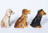 Três pequenas esculturas representando cachorro... - Três pequenas esculturas representando cachorros de porcelana policromada.