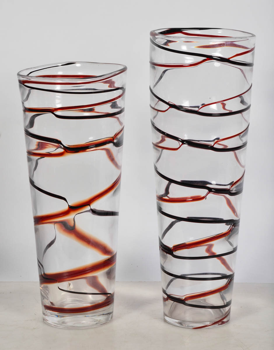 Dois vasos de vidro, na cor vermelha com frisos preto. Alts. 43 e 49...