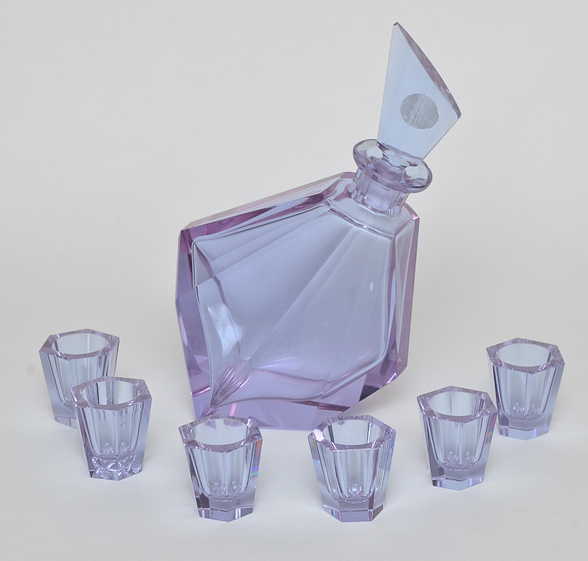 Licoreira de cristal na cor lilás com 6 copinhos. Alt. 23 cm.