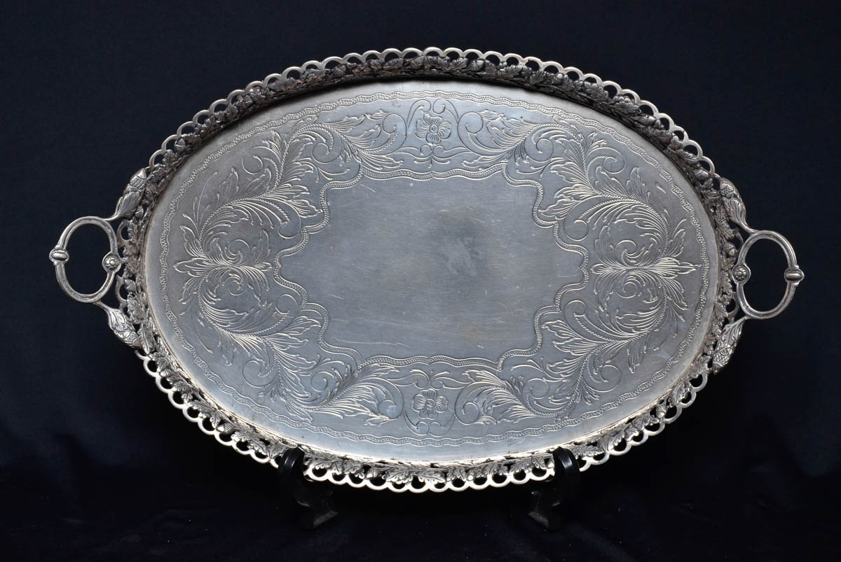Tabuleiro oval de prata brasileira com alças, cinzelada e guilhochada...