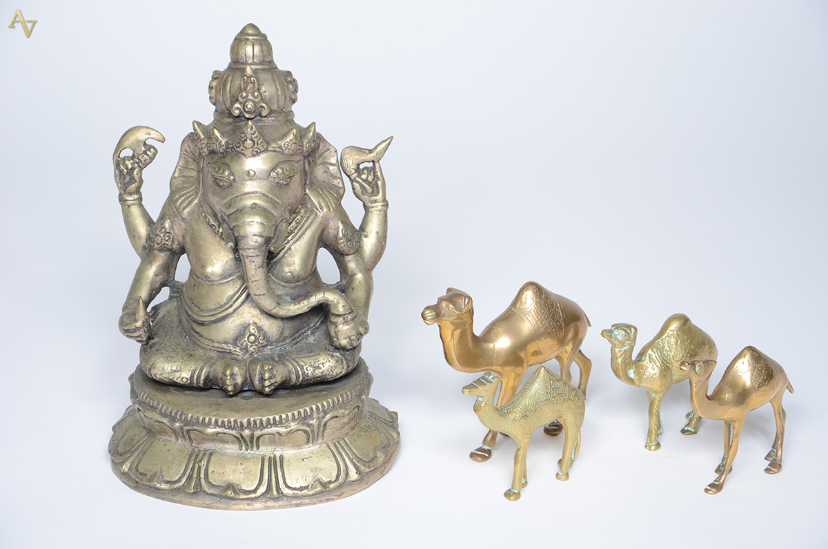 Cinco peças de metal dourado, sendo quatro camelos e uma Ganesha...