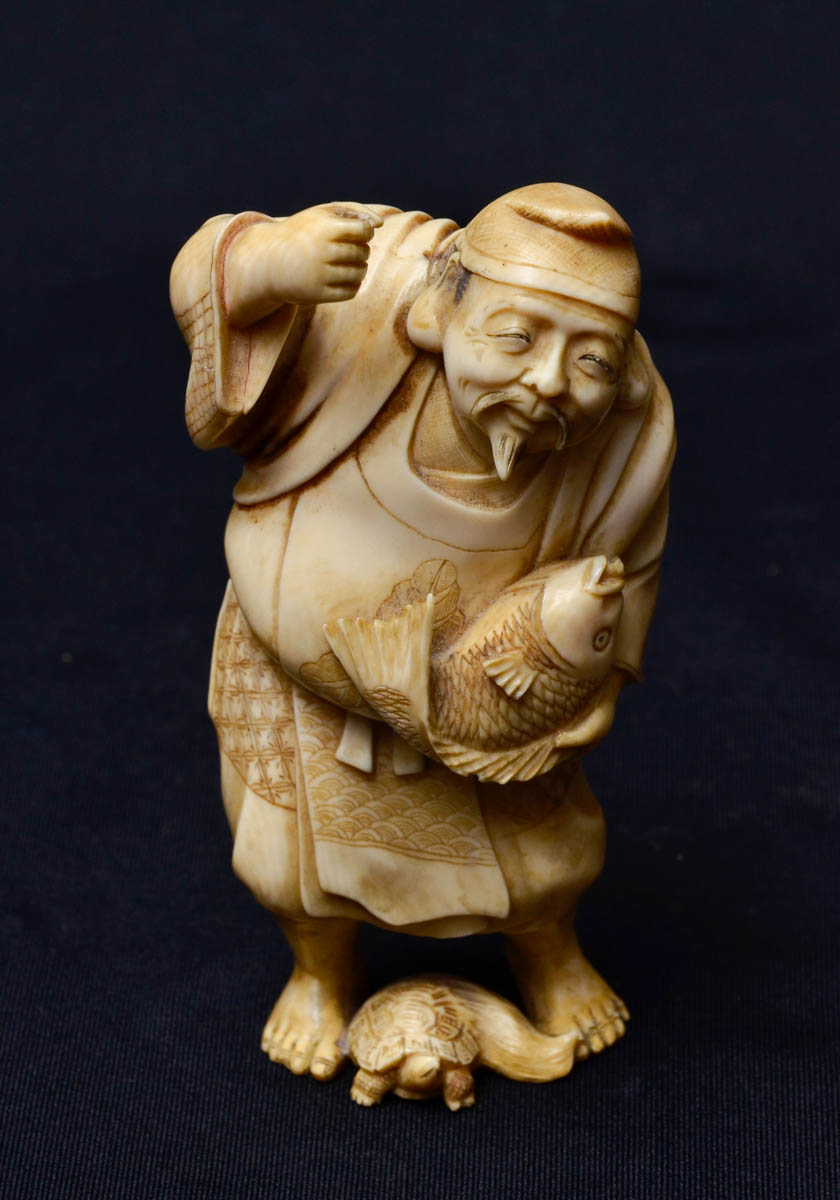 Estatueta de marfim repres. homem com peixe e tartaruga, assinado...