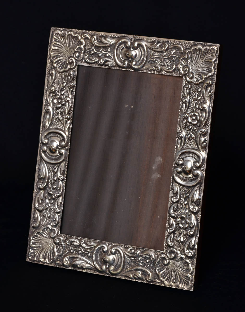 Porta retrato de prata com concheados e flores em relevo. Med. 25 x...