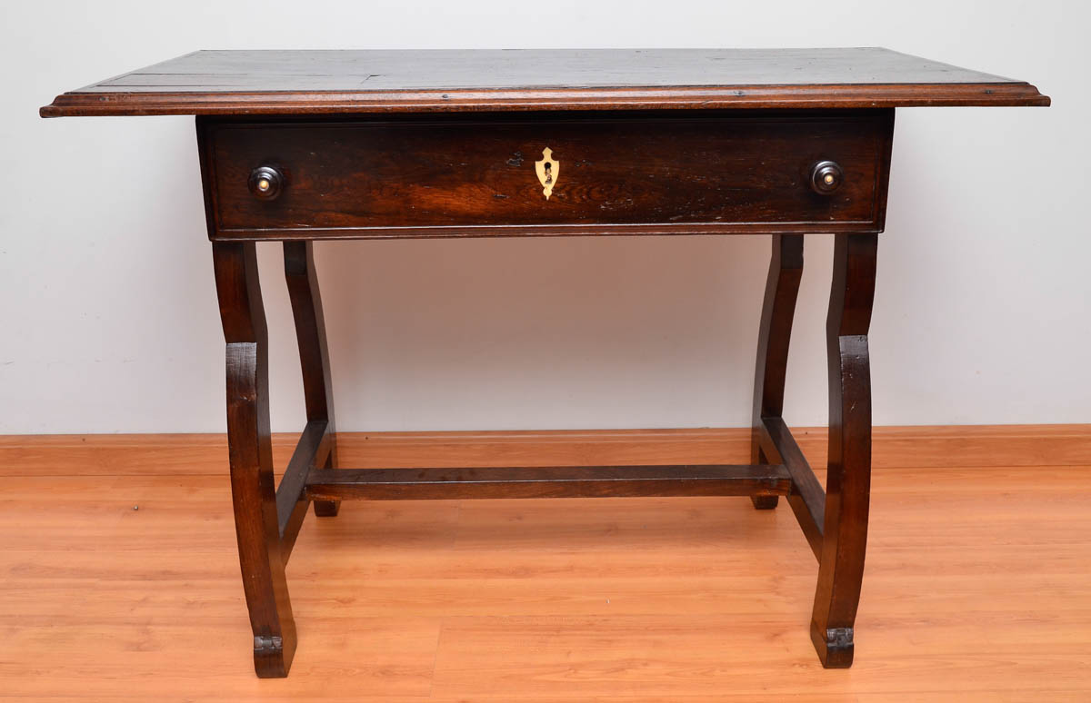 Mesa de madeira nobre com gaveta, pernas laterais arqueadas unidas...