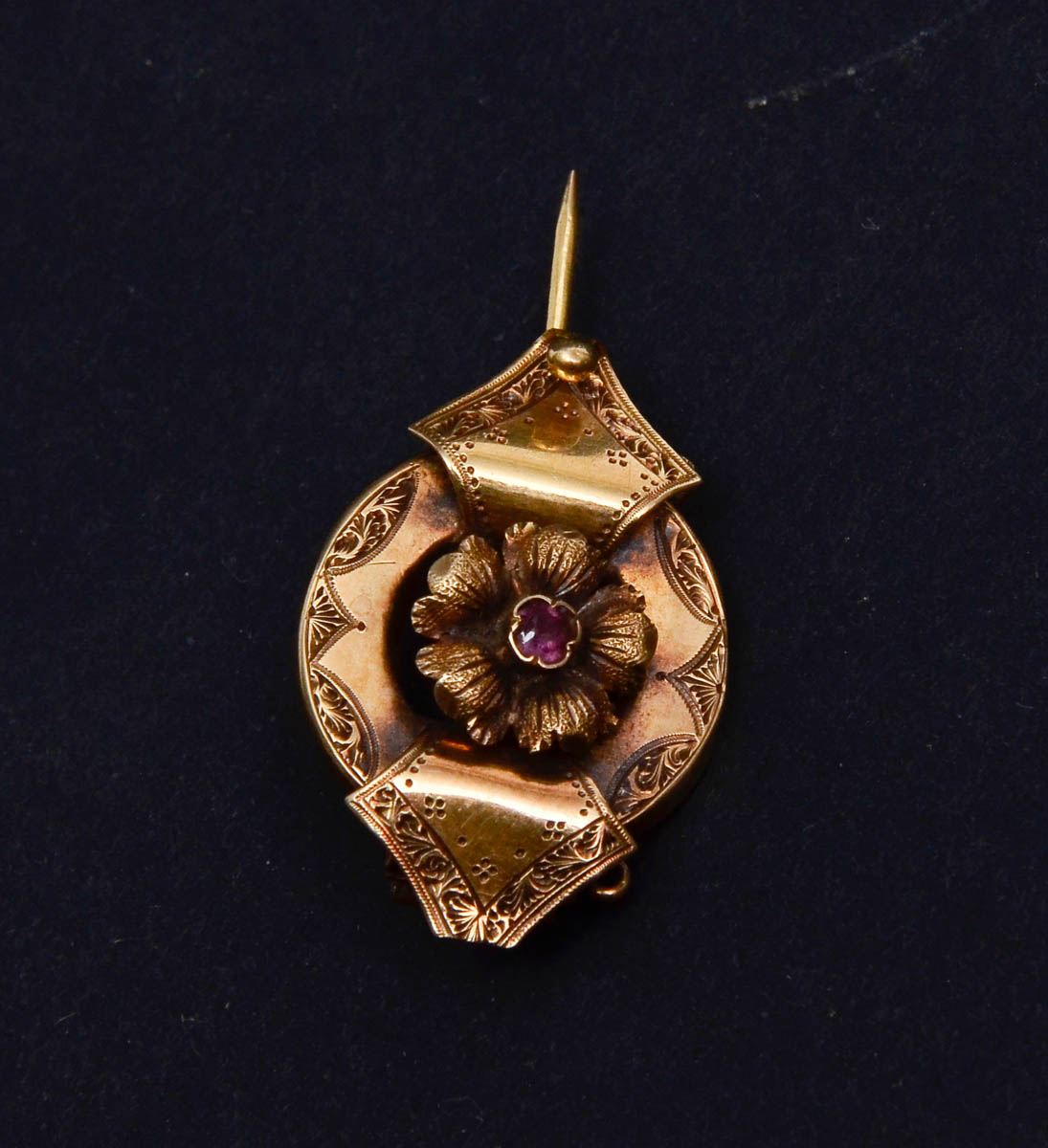 Broche em ouro amarelo 18 k com flor ao centro e 1 rubilita central...