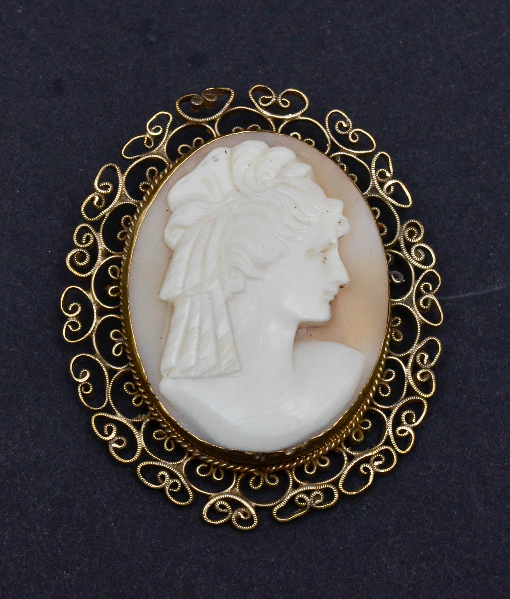 Broche camafeu com busto feminino, cabelos encaracolados e com...
