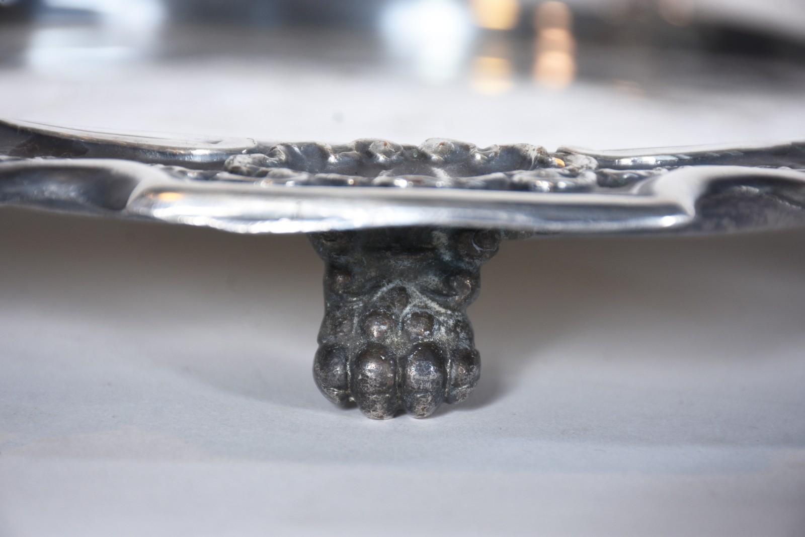 Salva de metal prateado, fundo cinzelado, borda com concheados em... - foto 4 de 6