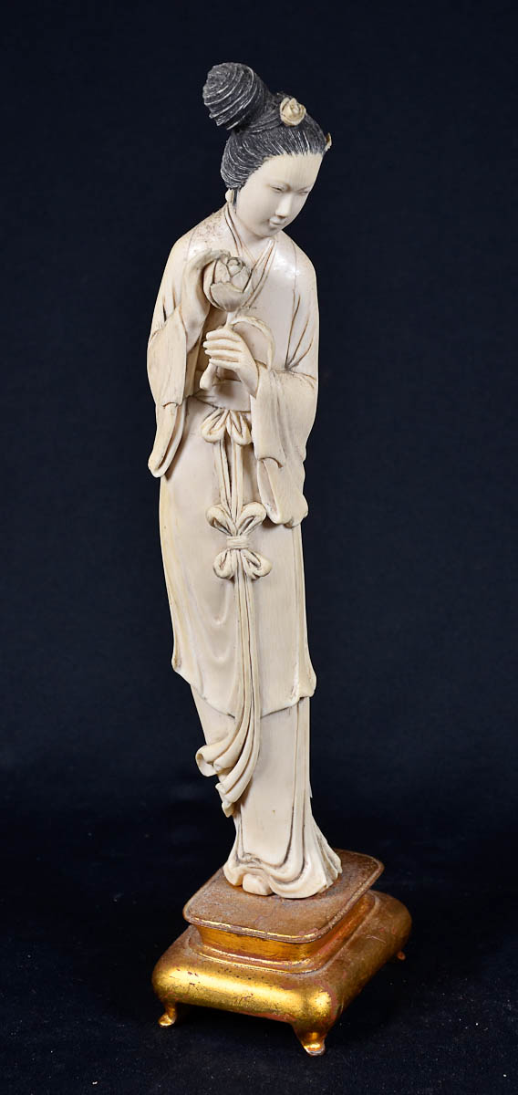 Estatueta de marfim repres. Gueixa com flor. Base de madeira dourada...