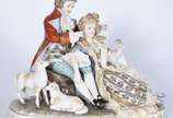 Grupo escultórico de porcelana europeia represe... - Grupo escultórico de porcelana europeia representando casal em cena galante no campo com carneiros. Marca no fundo, duas letras "C" entrelaçados...