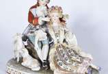 Grupo escultórico de porcelana europeia represe... - Grupo escultórico de porcelana europeia representando casal em cena galante no campo com carneiros. Marca no fundo, duas letras "C" entrelaçados...