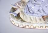 Grupo escultórico de porcelana europeia represe... - Grupo escultórico de porcelana europeia representando casal em cena galante no campo com carneiros. Marca no fundo, duas letras "C" entrelaçados...