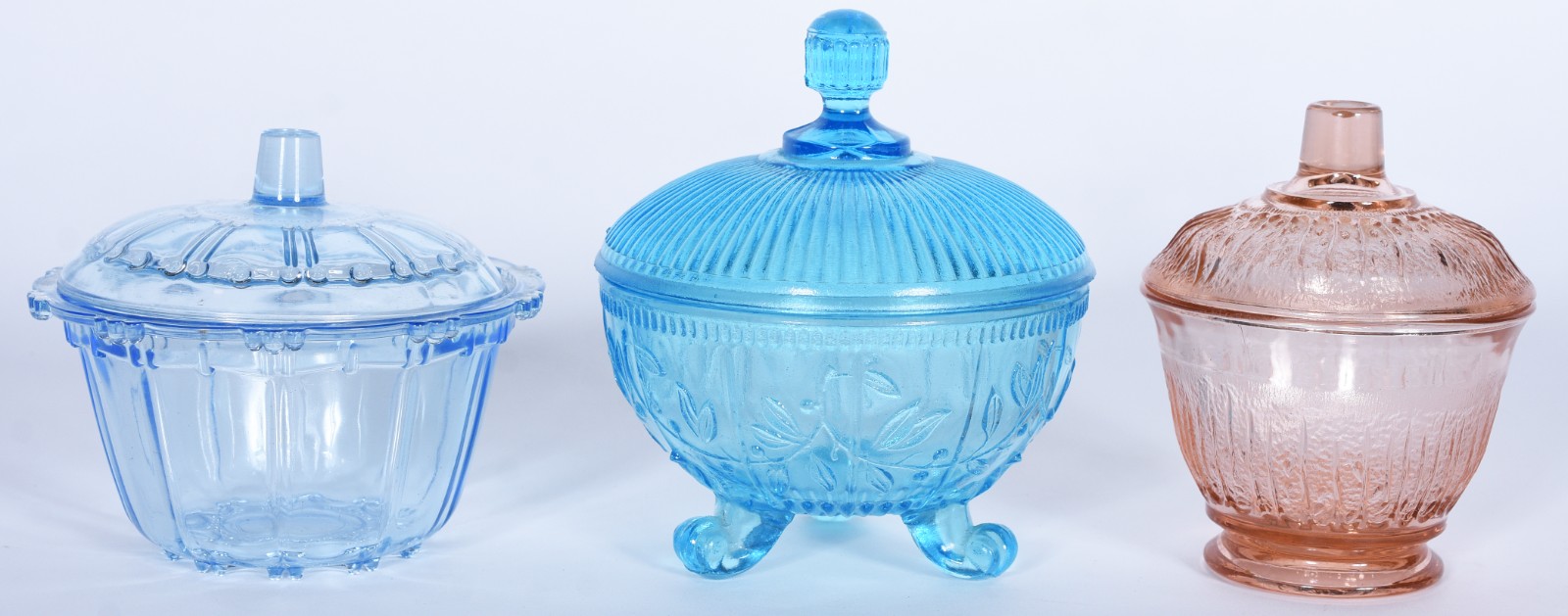 Três bombonieres de vidro trabalhado, sendo duas na cor azul e uma... - foto 1 de 9
