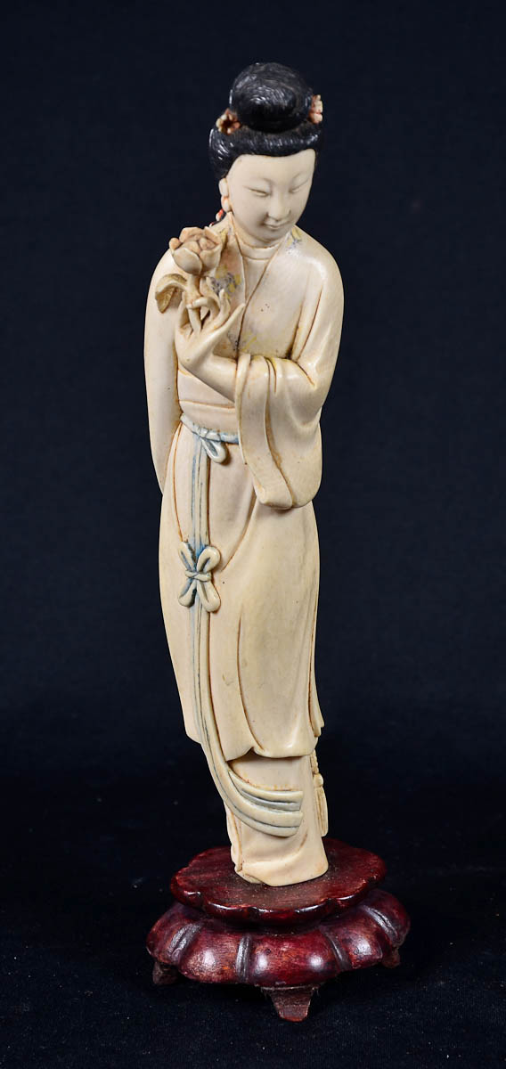 Gueixa de marfim com flor e cabelo preto. Base de madeira. Alt. 26 cm.