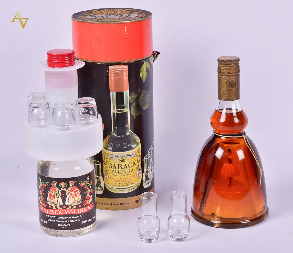 Duas garrafas, sendo 1 de licor com dançarina. Alt. 24 cm e outra...