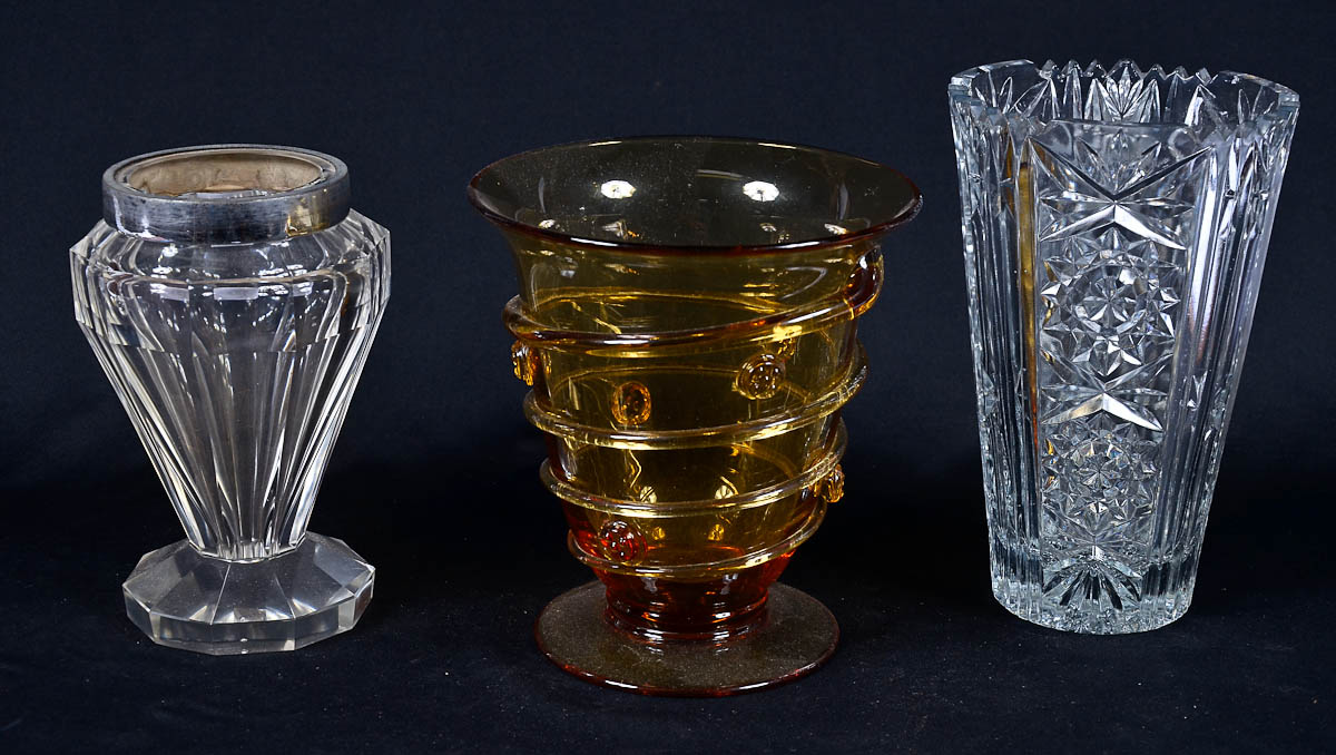 Três vasos de cristal, sendo um na cor ambar, um lapidado e outro...