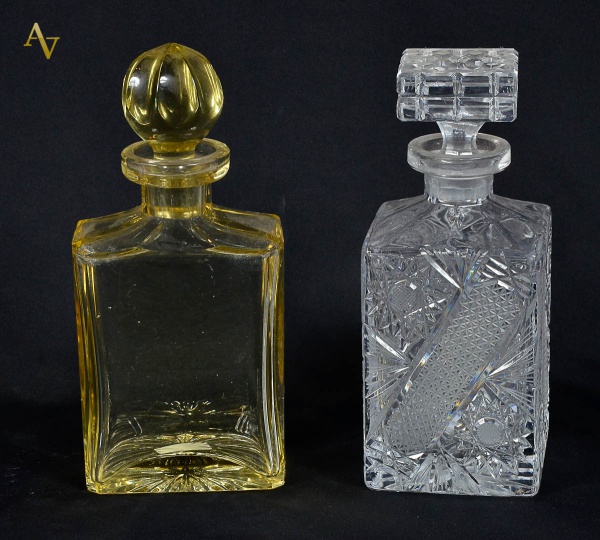 Duas garrafas de cristal lapidado, sendo um na cor ambar e outra...