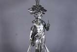 Centro de mesa Art Nouveau, base de metal prate... - Centro de mesa Art Nouveau, base de metal prateado na forma de figura de jovem, prato de cristal  lapidado doublé verde com borda em gomos. Base...