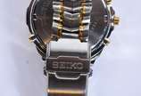 Seiko (1881),  - Relógio de pulso, alarme, calendário, em aço com detalhes dourados, fundo branco. Acompanha caixa  (Por motivos de segurança a peça não se encontra na