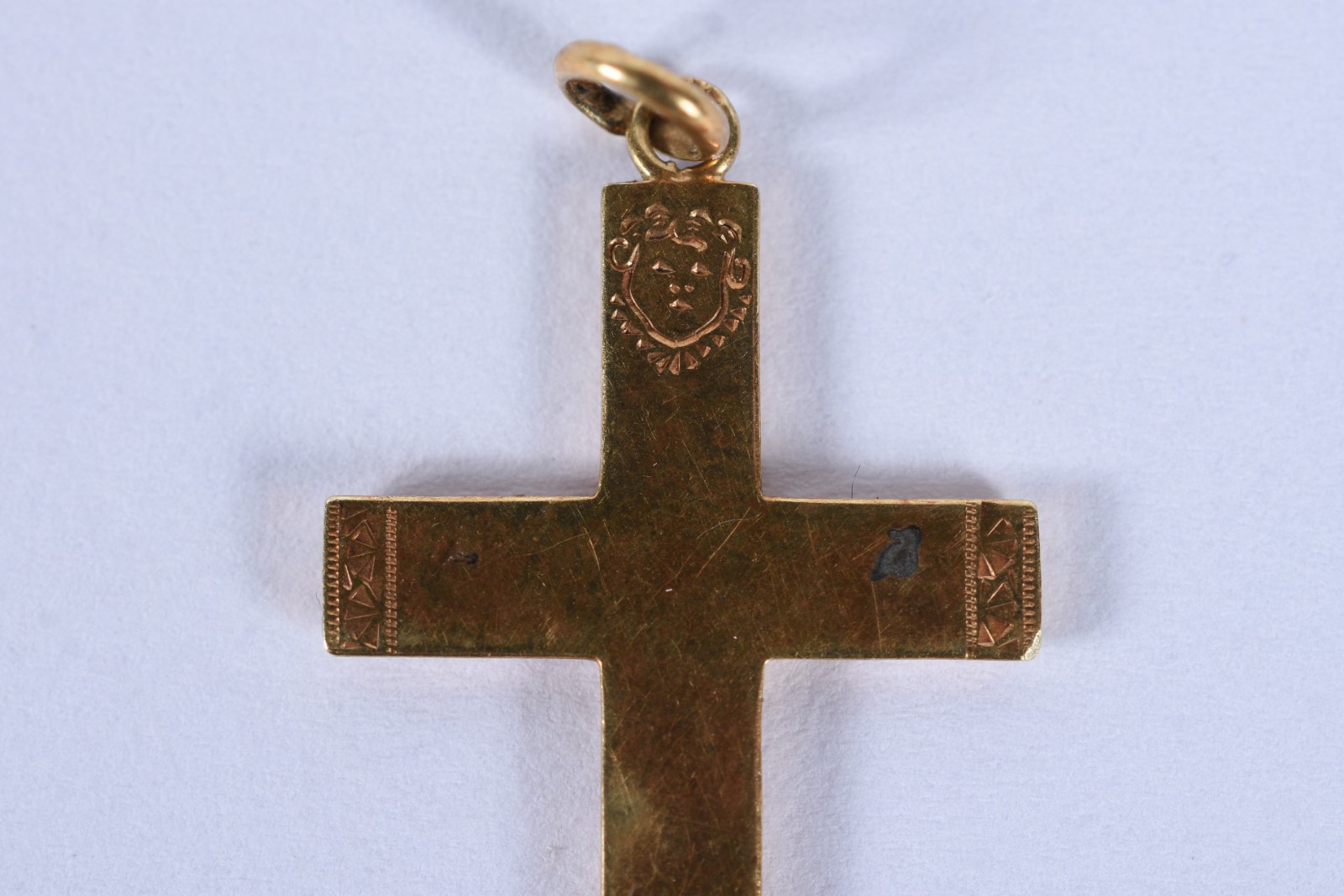 Três peças de ouro baixo, sendo: crucifixo, anel com pedra vermelha... - foto 7 de 9