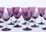 Serviço de taças de vidro na cor uva, composto ... - Serviço de taças de vidro na cor uva, composto de: 6 para vinho (1 com bicado) e 6 para champagne (1 com bicado). Total: 12 peças.