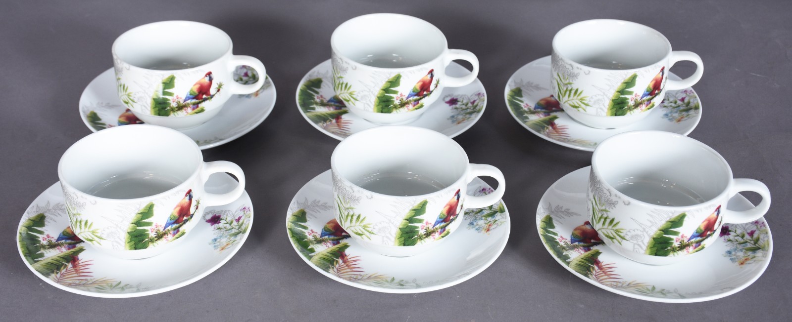 Seis xícaras de chá com pires de porcelana com aves e folhagens em... - foto 1 de 9
