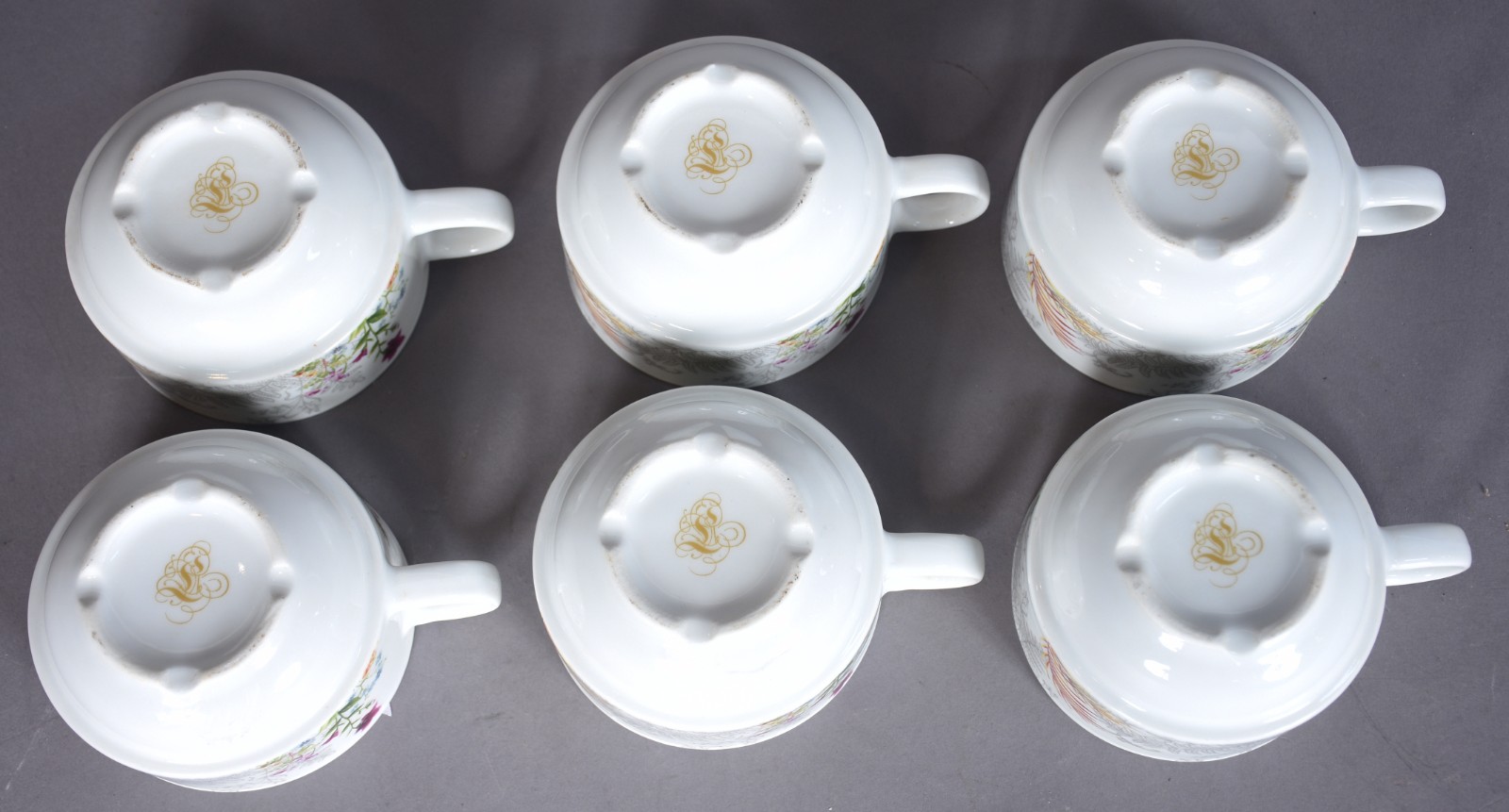 Seis xícaras de chá com pires de porcelana com aves e folhagens em... - foto 7 de 9