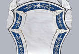 Espelho estilo veneziano com detalhe na cor azu... - Espelho estilo veneziano com detalhe na cor azul. Alt. 1.26 m; larg. 73 cm.