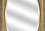 Espelho oval bisotado c/ moldura de madeira pat... - Espelho oval bisotado c/ moldura de madeira patinada. Med. externa. 66 x 44 cm.