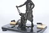 Tinteiro decorado com escultura de petit bronze... - Tinteiro decorado com escultura de petit bronze representando ferreiro, base de mármore.