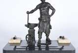 Tinteiro decorado com escultura de petit bronze... - Tinteiro decorado com escultura de petit bronze representando ferreiro, base de mármore.