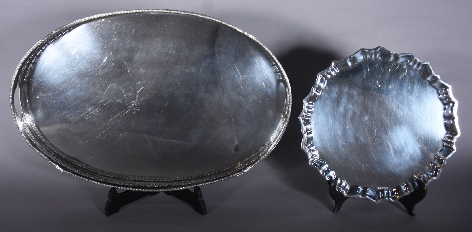 Duas bandejas de metal prateado, sendo uma oval com alças e galeria... - foto 1 de 7