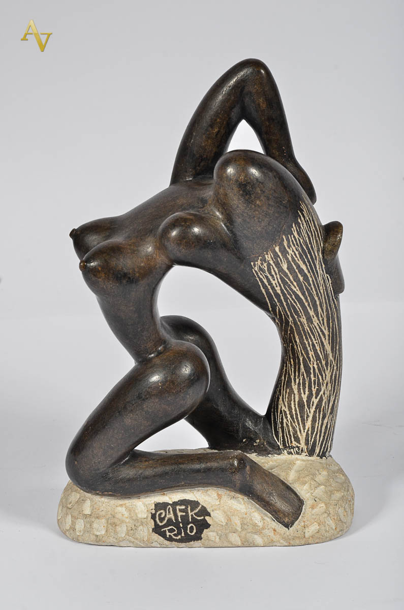 Escultura de pedra representando figura feminina. Alt. 26 cm.