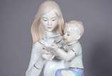 Escultura de porcelana representando dama com c... - Escultura de porcelana representando dama com criança.