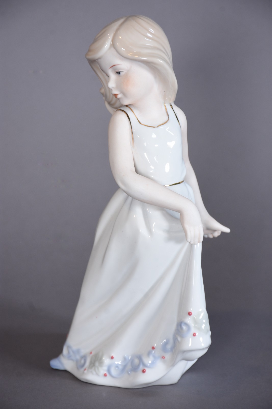 Escultura de porcelana representando menina segurando saia. - foto 1 de 7