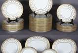 Aparelho de jantar de porcelana inglesa "MINTON... - Aparelho de jantar de porcelana inglesa "MINTONS", na cor branca ricamente decorado com rendilhados e frisos dourados, composto de: 23 pratos ra...