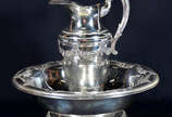 Jarra com bacia de metal espessurado a prata. (... - Jarra com bacia de metal espessurado a prata. (alt.total 39 cm. diam.bacia 46 cm)