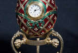Ovo no estilo Fabergé c/ relógio e base de meta... - Ovo no estilo Fabergé c/ relógio e base de metal. Alt. total 12 cm.