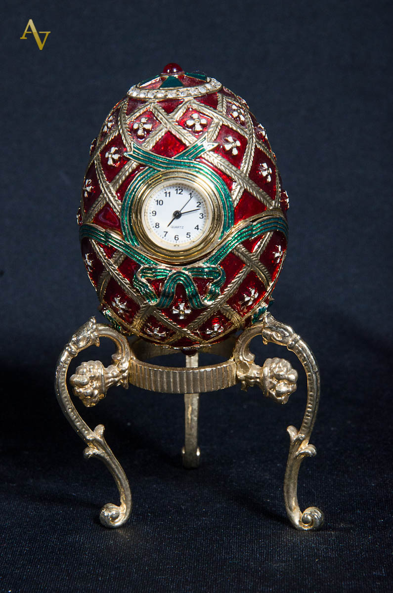 Ovo no estilo Fabergé c/ relógio e base de metal. Alt. total 12 cm.