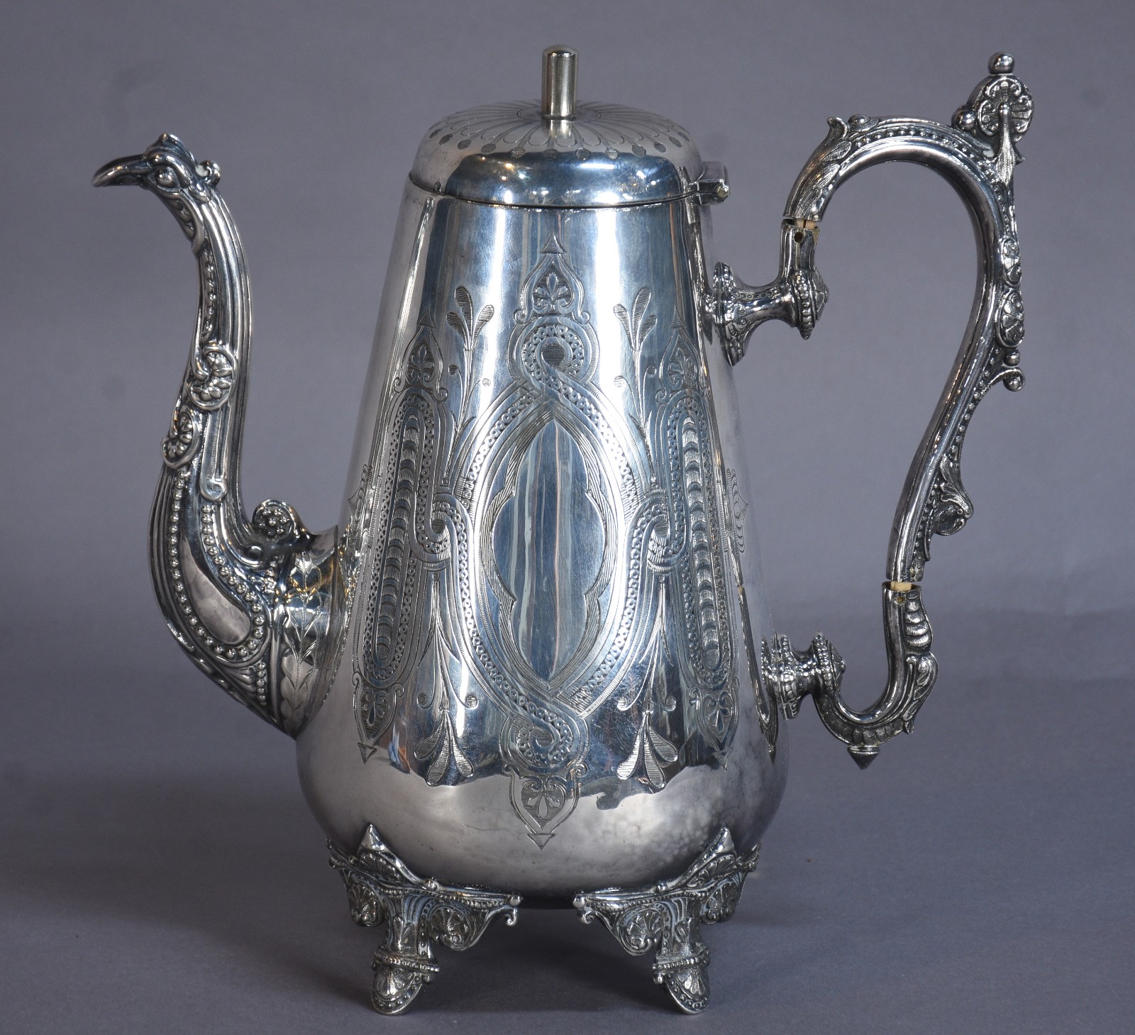 Elegante bule de metal prateado ricamente cinzelado, bico na forma de... - foto 1 de 8
