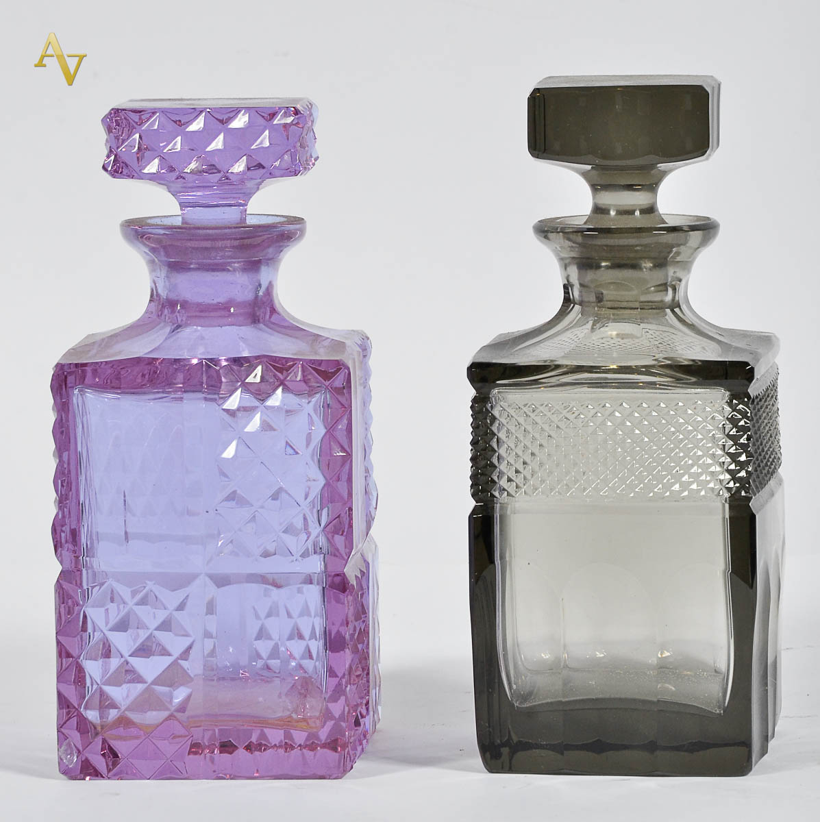 Duas garrafas de cristal lapidado, sendo 1 na cor lilas ( com...