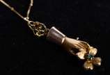 Colar de ouro 18k., contraste 750 mls com pinge... - Colar de ouro 18k., contraste 750 mls com pingente de "bolinhas" no feitio figa e flor e esmeralda. (Por motivos de segurança a peça não se enco...