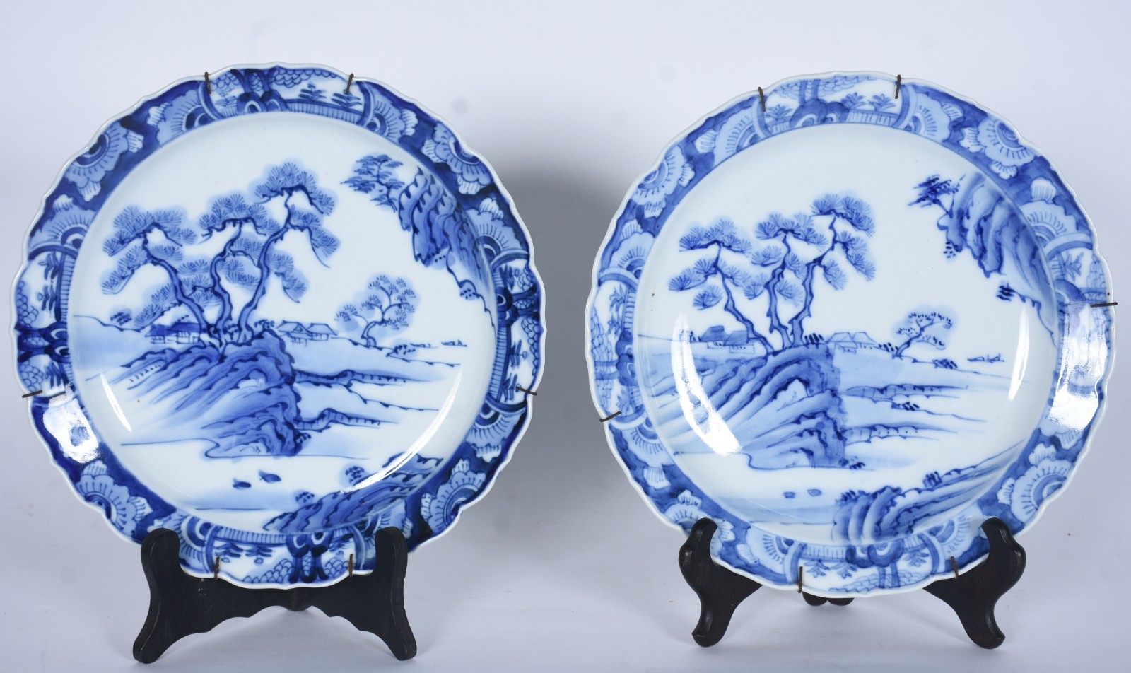 Par de pratos de porcelana oriental decorados com paisagens em azul e... - foto 1 de 7