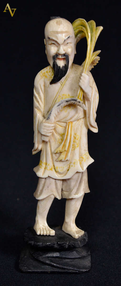 Estatueta de marfim repres. homem com trigo. Alt. 15cm.