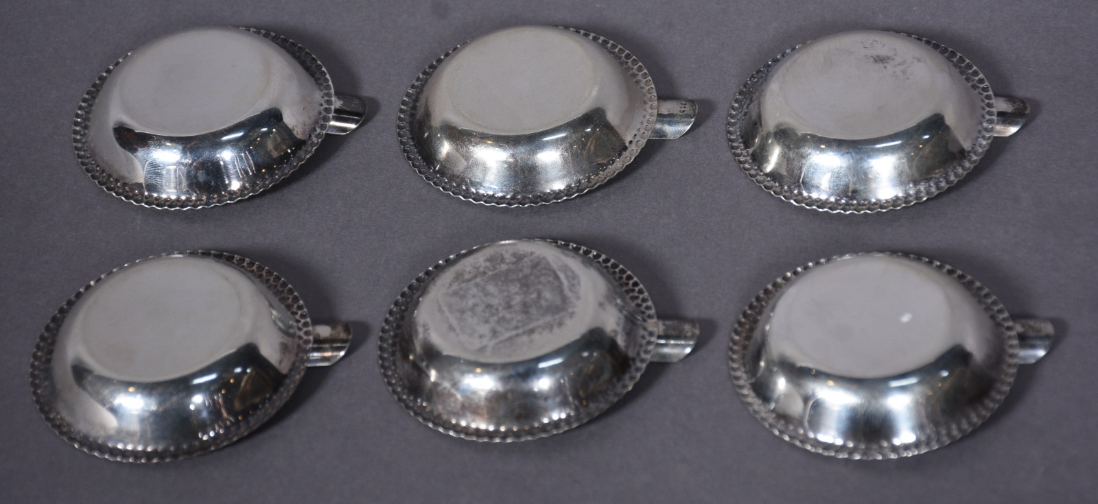 Seis cinzeiros individuais de metal prateado com bordas peroladas. - foto 2 de 5