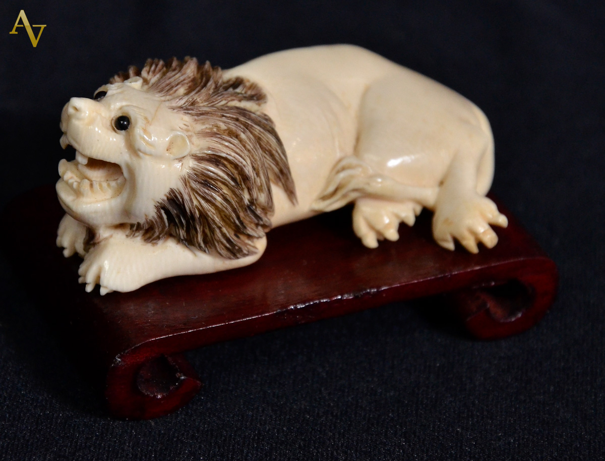 Netsuke de marfim, representando leao.Comp. 6,5 cm.