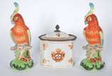 Tres peças de porcelana policromada, sendo par ... - Tres peças de porcelana policromada, sendo par de papagaios e caixa decorada com brazões.